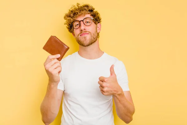 Young Caucasian Man Holding Wallet Isolated Yellow Background Smiling Raising — Stock Photo, Image