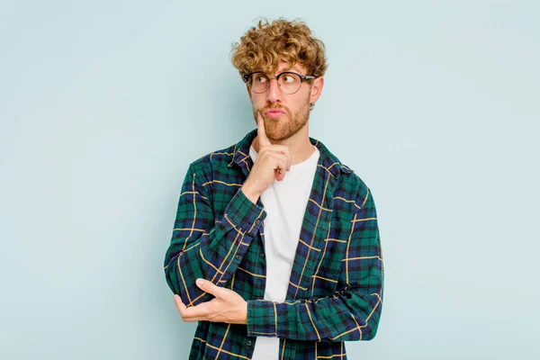 Joven Hombre Caucásico Aislado Sobre Fondo Azul Contemplando Planeando Una —  Fotos de Stock