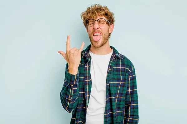 Joven Hombre Caucásico Aislado Sobre Fondo Azul Mostrando Gesto Roca —  Fotos de Stock