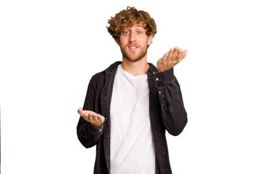 Yeşil krom arka planda izole genç beyaz adam kollarıyla ölçek yapar, mutlu ve kendinden emin hisseder..