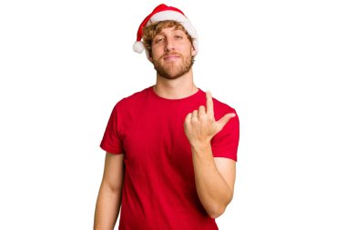 Beyaz arka planda izole edilmiş Noel Baba şapkası takan genç beyaz adam sanki seni davet ediyormuş gibi seni işaret ediyor..