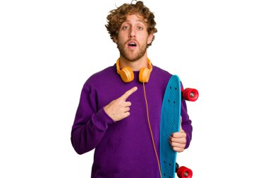 Young skater caucasian man isolated on white background pointing to the side