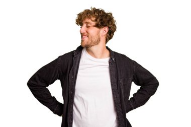 Yeşil krom arka planda izole edilmiş genç beyaz adam mutlu bir şekilde gülüyor ve ellerini karnının üstünde tutarak eğleniyor..