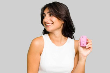 Arabanın anahtarlarını tutan genç Hintli kadın. Gülümsüyor, neşeli ve keyifli görünüyor..