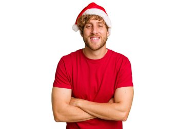 Beyaz arka planda izole edilmiş Noel Baba şapkası takan genç beyaz bir adam gülüyor ve eğleniyor..