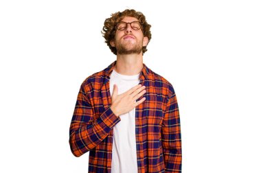 Yeşil krom arka planda izole edilmiş genç beyaz adam yüksek sesle gülüyor ve elini göğsüne koyuyor..