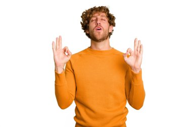 Kafkasyalı genç adam yeşil krom arka planda izole edilmiş yoğun çalışma gününden sonra rahatlıyor, yoga yapıyor..