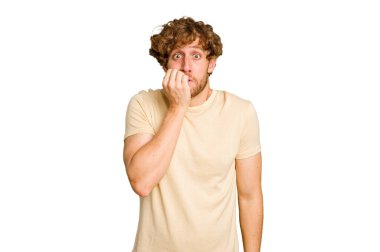 Genç beyaz adam yeşil krom arka planda izole edilmiş tırnak yiyor, gergin ve çok endişeli..