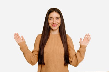 Kafkasyalı uzun saçlı genç kadın, kendini izole etmiş, parmaklarıyla küçük bir şey tutuyor, gülümsüyor ve kendinden emin..