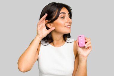 Elinde araba anahtarı olan genç Hintli bir kadın bir dedikoduyu dinlemeye çalışırken izole edilmiş..