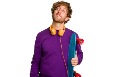 Young skater caucasian man isolated on white background dreaming of achieving goals and purposes
