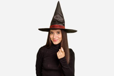 Cadılar bayramı için cadı gibi giyinmiş genç beyaz kadın izole edilmiş, seni işaret ederek sanki seni davet ediyormuş gibi..