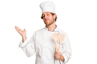 Beyaz arka planda izole edilmiş genç aşçı bir avuç içinin fotokopi çektiğini ve başka bir eli belinde tuttuğunu gösteriyor..