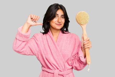 Sırt kaşıyıcısı tutan genç Hintli kadın kendini gururlu ve kendinden emin hissediyor, örnek olarak..