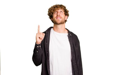 Yeşil krom arka planda izole edilmiş genç beyaz adam iki ön parmağı da boş bir alan gösteriyor..