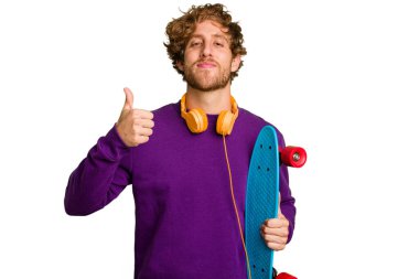 Young skater caucasian man isolated on white background smiling and raising thumb up