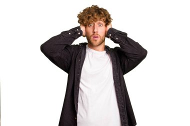 Kafkasyalı genç adam yeşil krom arka planda izole edilmiş kulakları kulaklarıyla kapatıyor çok fazla ses duymamaya çalışıyor..