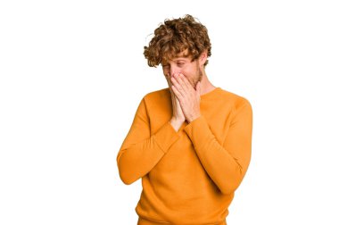 Yeşil krom arka planda izole edilmiş genç beyaz bir adam bir şeye gülüyor, elleriyle ağzını kapatıyor..