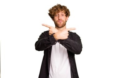 Yeşil krom arka plan noktalarında izole genç beyaz adam, iki seçenek arasında seçim yapmaya çalışıyor.