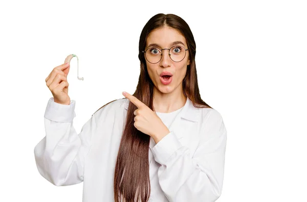 Genç Otorhinolaryngolog Elinde Işitme Cihazı Tutan Beyaz Kadın Kenarı Işaret — Stok fotoğraf