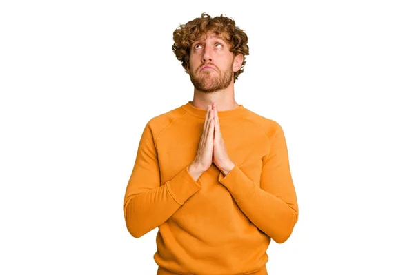 口の近くで祈る手を握っている緑のクロマの背景に隔離された若い白人男性は 自信を感じています — ストック写真