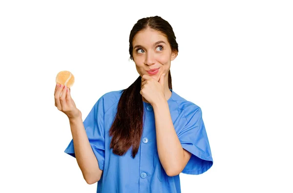 Jonge Blanke Fysiotherapeut Vrouw Houdt Een Tennisbal Geïsoleerd Kijken Zijwaarts — Stockfoto