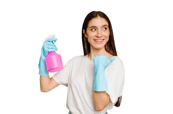 Young Cleaner Woman Isolated Points Thumb Finger Away Laughing Carefree — Stock Photo, Image