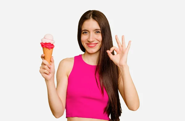 年轻的高加索女人吃着冰淇淋 孤立地快乐而自信地做出了好的姿态 — 图库照片