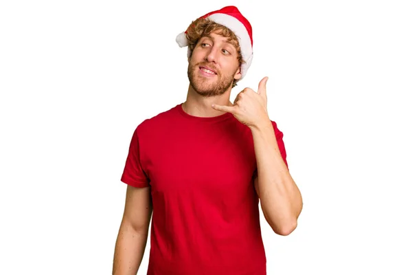 若いですCaucasian男身に着けていますAクリスマスサンタ帽子隔離された白い背景ショーA携帯電話の呼び出しジェスチャーとともに指 — ストック写真