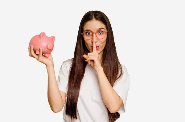 Young Caucasian Woman Holding Piggy Bank Isolated Keeping Secret Asking — Stock Photo, Image