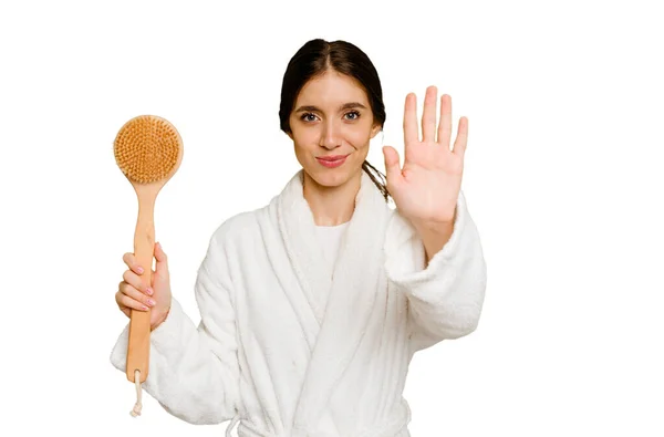 Młoda Kaukaska Kobieta Trzyma Szczotkę Prysznica Odizolowany Wyciągniętą Ręką Pokazując — Zdjęcie stockowe
