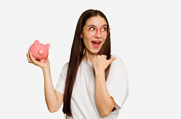 Young Caucasian Woman Holding Piggy Bank Isolated Points Thumb Finger — Stock Photo, Image