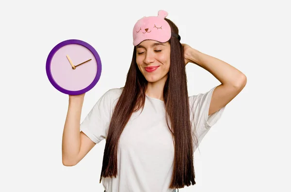 Young Caucasian Woman Wearing Pajama Holding Clock Touching Back Head — Stock Photo, Image