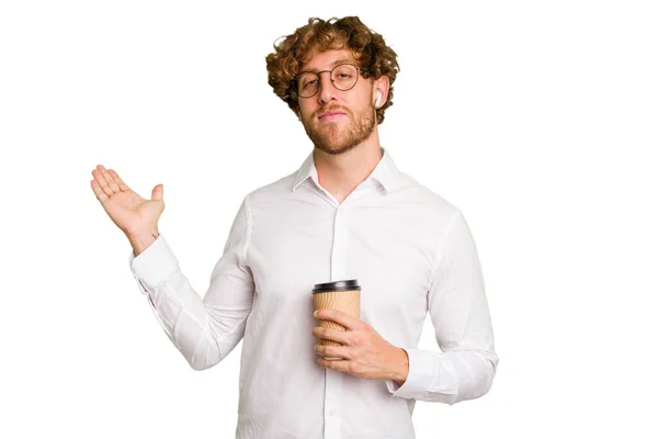 コーヒーを持っている実業家は ヤシの上にコピースペースを示す白い背景に隔離され 腰にもう一つの手を保持する — ストック写真