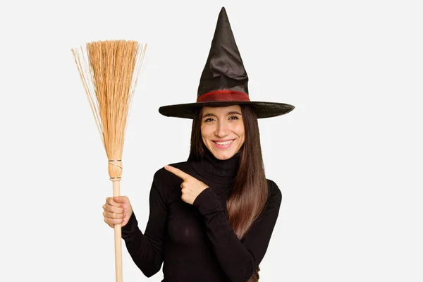 Young Caucasian Woman Dressed Witch Holding Broom Isolated Smiling Pointing — Stock Photo, Image