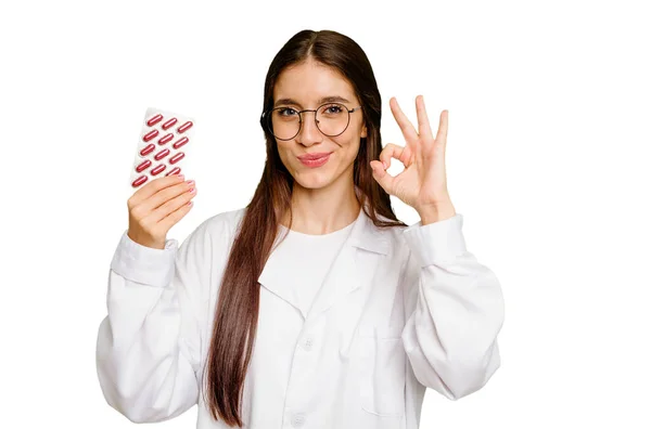 Młoda Farmaceutka Trzyma Tabletkę Tabletek Odizolowanych Wesoły Pewny Siebie Pokazując — Zdjęcie stockowe