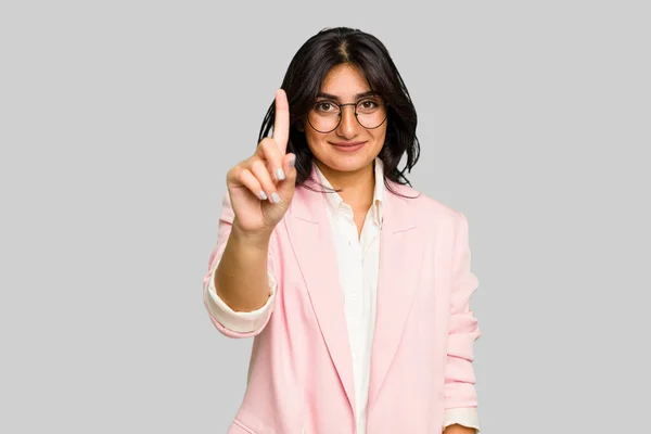 若いですインドのビジネス女性を身に着けていますピンクのスーツ絶縁された番号1とともに指 — ストック写真