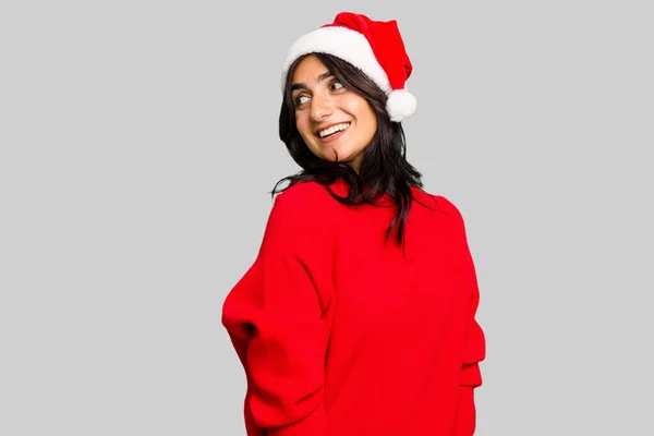 若いですインド人女性祝いクリスマスを身に着けていますサンタ帽子隔離された表情脇笑顔 陽気で楽しい — ストック写真