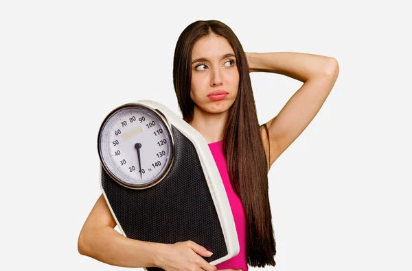 Young Caucasian Woman Holding Scale Isolated Touching Back Head Thinking — Stock Photo, Image