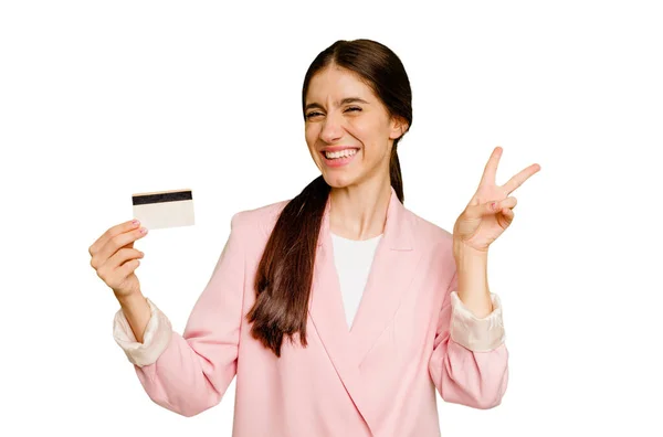 ビジネスの原因アジアの女性は指で平和のシンボルを示す喜びと屈託のない孤立したクレジットカードを保持 — ストック写真