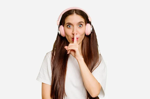 Jovem Caucasiana Usando Fones Ouvido Isolado Mantendo Segredo Pedindo Silêncio — Fotografia de Stock