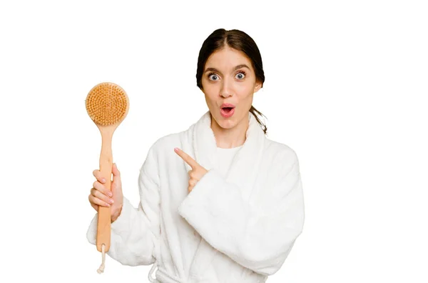 Young Caucasian Woman Holding Shower Brush Isolated Pointing Side — Stock Photo, Image