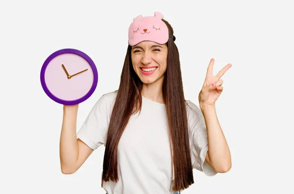 Jovem Caucasiana Vestindo Pijama Segurando Relógio Alegre Despreocupado Mostrando Símbolo — Fotografia de Stock