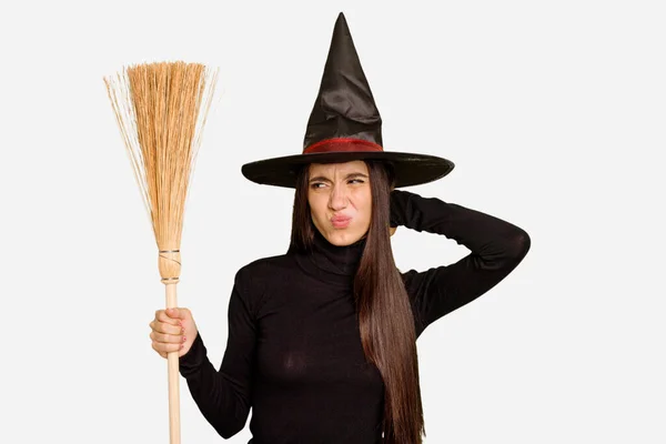 年轻的高加索女人穿得像个女巫 手里拿着一把扫帚 孤零零地碰着头 思考着 做出了一个选择 — 图库照片