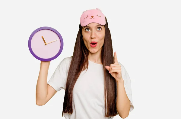 Young Caucasian Woman Wearing Pajama Holding Clock Pointing Upside Opened — Stock Photo, Image