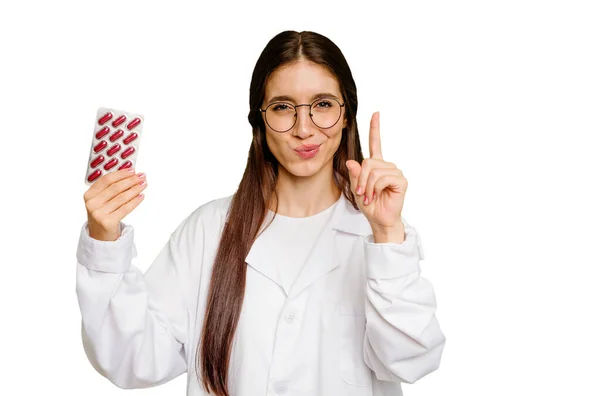 Joven Farmacéutica Sosteniendo Una Tableta Pastillas Aisladas Mostrando Número Uno — Foto de Stock