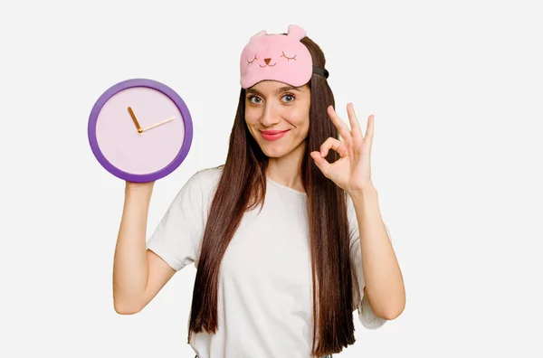 Jovem Mulher Caucasiana Vestindo Pijama Segurando Relógio Alegre Confiante Mostrando — Fotografia de Stock