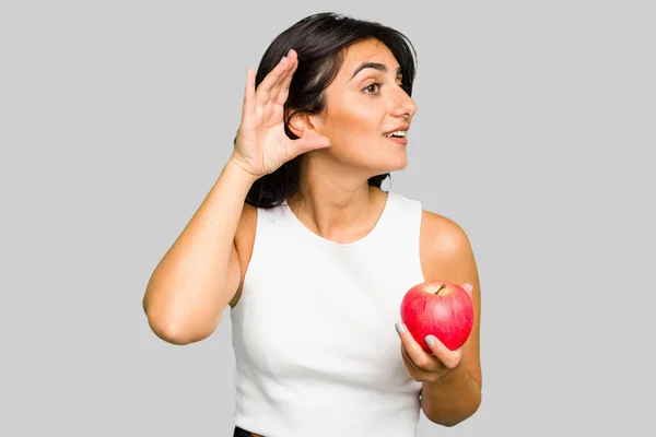 Young Indian Woman Holding Apple Healthy Lifestyle Isolated Trying Listening — Stock Photo, Image