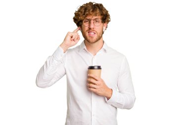 Beyaz arka planda izole edilmiş kulakları elleriyle kapatmak için elinde kahve tutan beyaz bir adam..