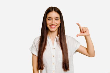 Kafkasyalı uzun saçlı genç kadın, kendini izole etmiş, parmaklarıyla küçük bir şey tutuyor, gülümsüyor ve kendinden emin..